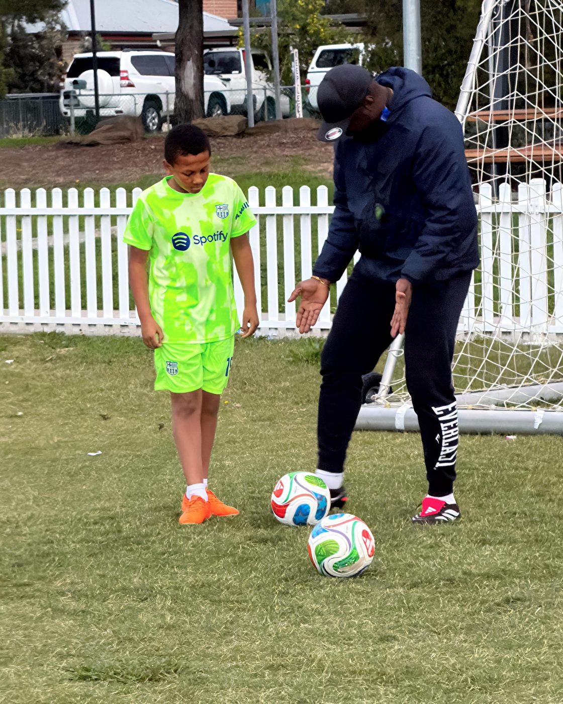 Coach demonstrating a ball skill to a player